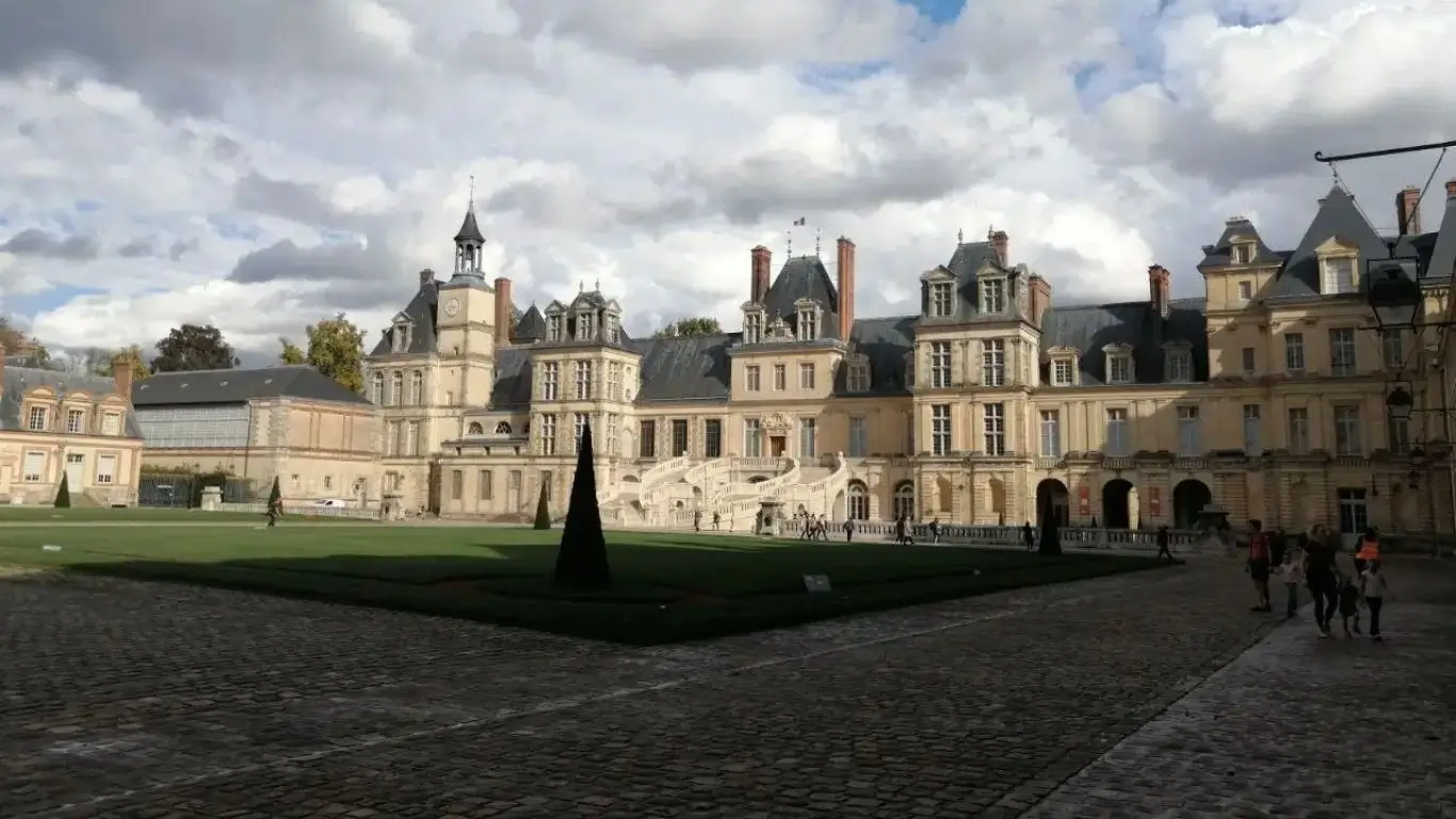 Sortie Culturelle pour Seniors au Château de Fontainebleau | Ateliers du Lien Groupe de jeunes et seniors visitant le Château de Fontainebleau avec un accompagnateur bienveillant - Ateliers du Lien